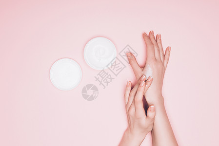 在粉红色上单独隔离的手用奶油背景图片
