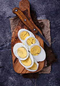 在砧板上煮熟切片的鸡蛋顶视图图片