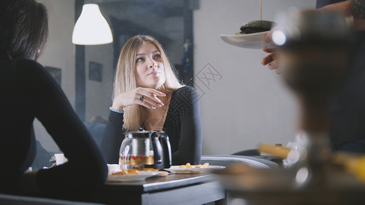 在咖啡馆聊天的年轻女朋友服务员图片