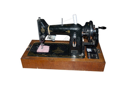 白色背景上带有线轴的旧手工缝纫机图片