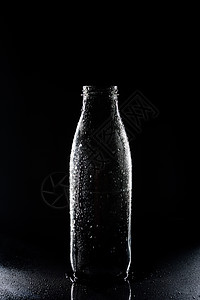 一个透明的空玻璃瓶在黑图片