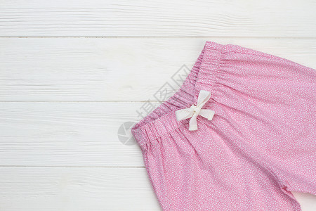 白纹粉色裤子木制背景的睡衣服装图片