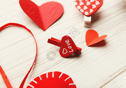 红纸心和衣服夹在白色生锈木板的缝合上快乐情人节卡片模型复制空间选择图片
