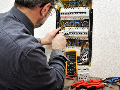 将电缆固定到住宅电气面板断路器端子的技术电工图片