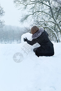 女人从雪中塑造出一颗大心脏背景图片