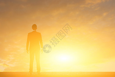 商人站在日落的对面天空图片