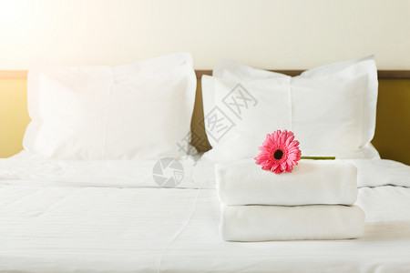 在旅馆房间的床上堆满毛巾和花朵图片