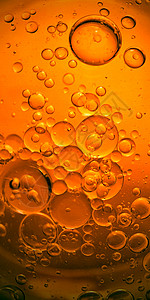 黄色背景烹饪橄榄油滴和水的泡图片