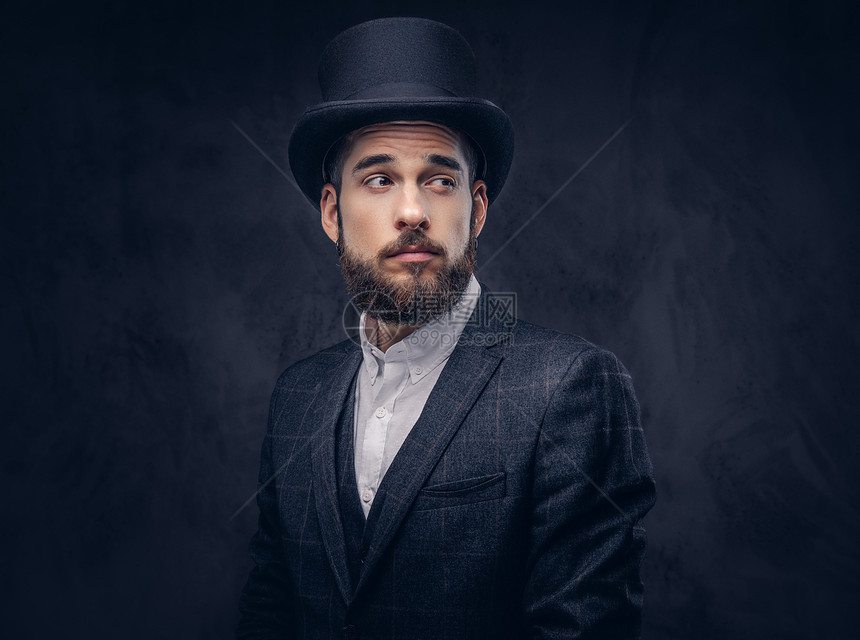 一个穿着优雅西装和圆帽的时髦胡子男肖像在图片