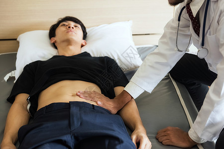 医生用手触摸腹部的亚洲年轻病人图片