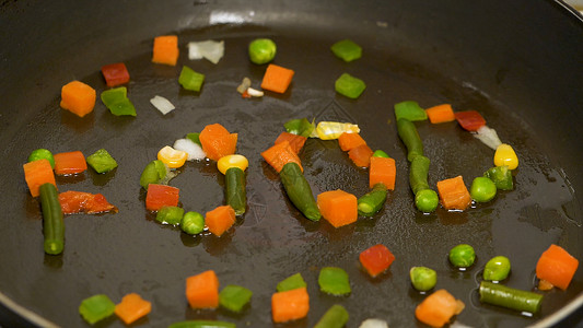 锅中切碎的蔬菜被收集在食物一词中在锅里翻炒蔬菜蔬菜飞到半空中图片