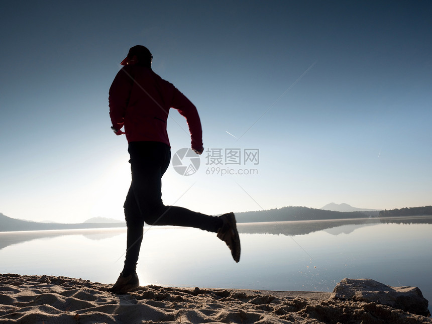 日落时在湖边海滩游荡地图片