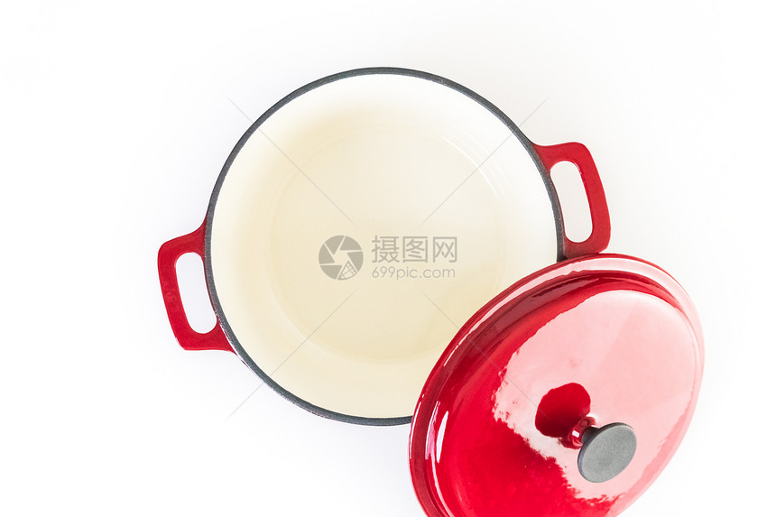 在白色背景的红色搪瓷铸铁盖了荷兰烤箱图片