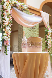 盛装玫瑰和白月花蜡烛和蜜桃彩色织物的婚纱图片