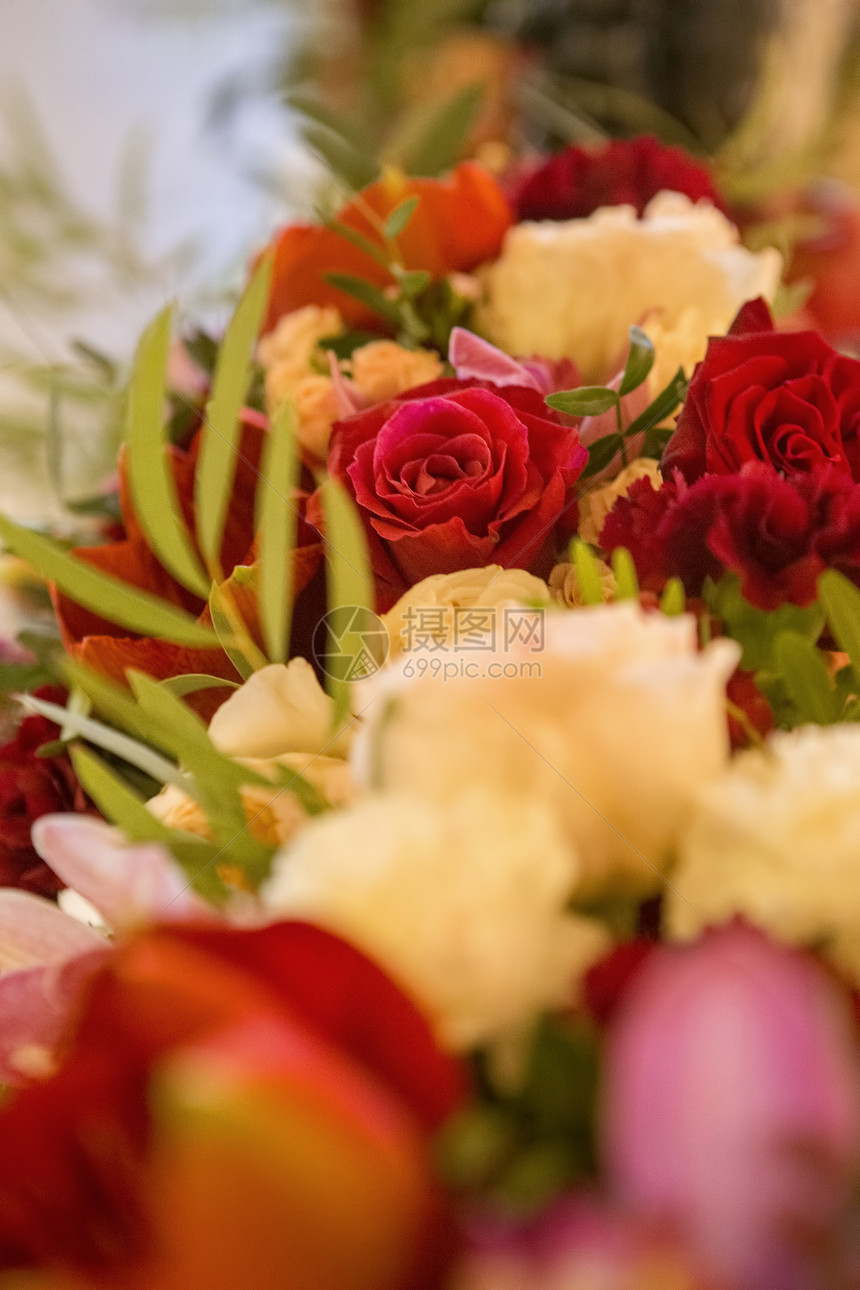 彩色鲜花在一张婚礼桌边四周环绕着板图片