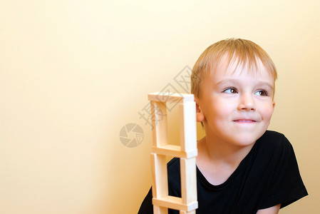 活生的搞笑男孩正在用自然木制建筑图片