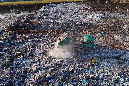 关于卡车在垃圾填埋场卸载废物的空中无人图片