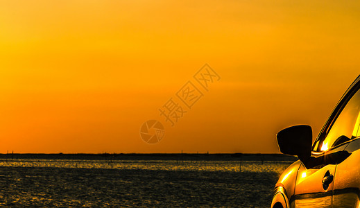 具有运动和现代设计的蓝色紧凑型SUV车在日落时分停在海边的混凝土路上图片