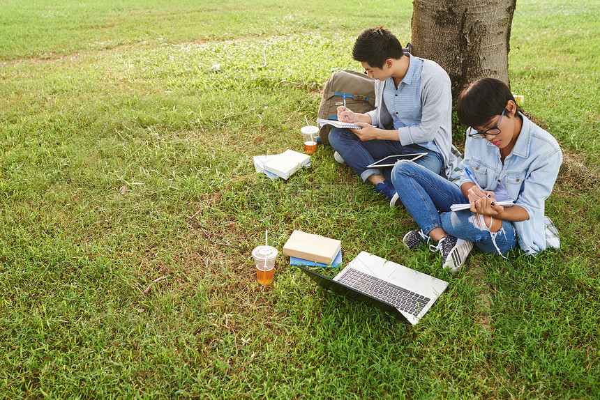 两名集中的高中学生坐在公园草图片