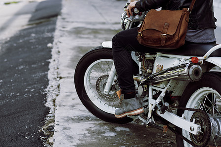 坐在旧摩托车和催燃气踏板上的摩托车图片