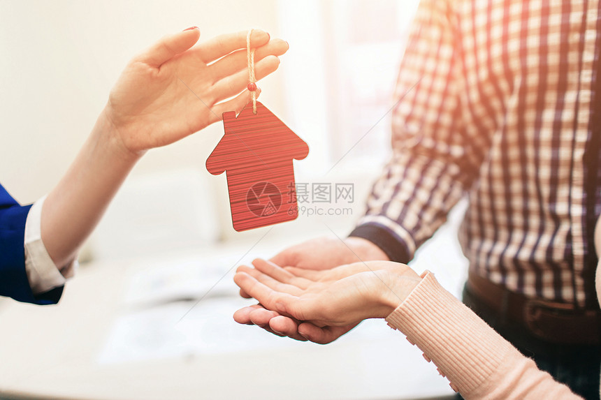 年轻的家庭夫妇购买出租物业房地产代理给男人和女人提供咨询签订购买房屋或公寓或公寓的合同他手里拿着一图片