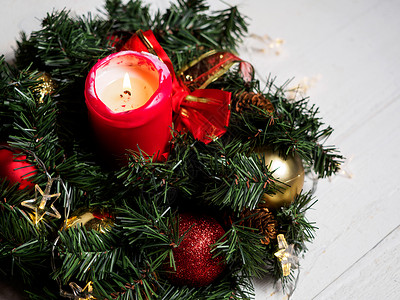 圣诞云杉树枝花环与木板上的蜡烛图片