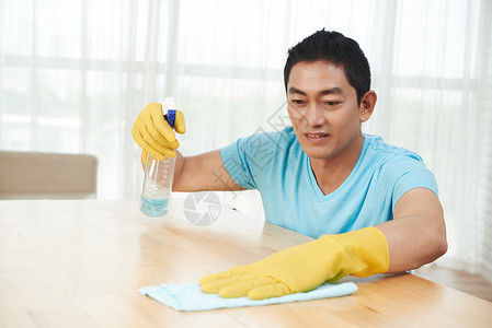 越南男子用清洁剂清洗桌表图片