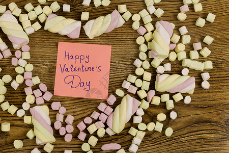 情人节快乐文本装饰了心脏形的棉花糖木质背景上的爱情概念复制空图片