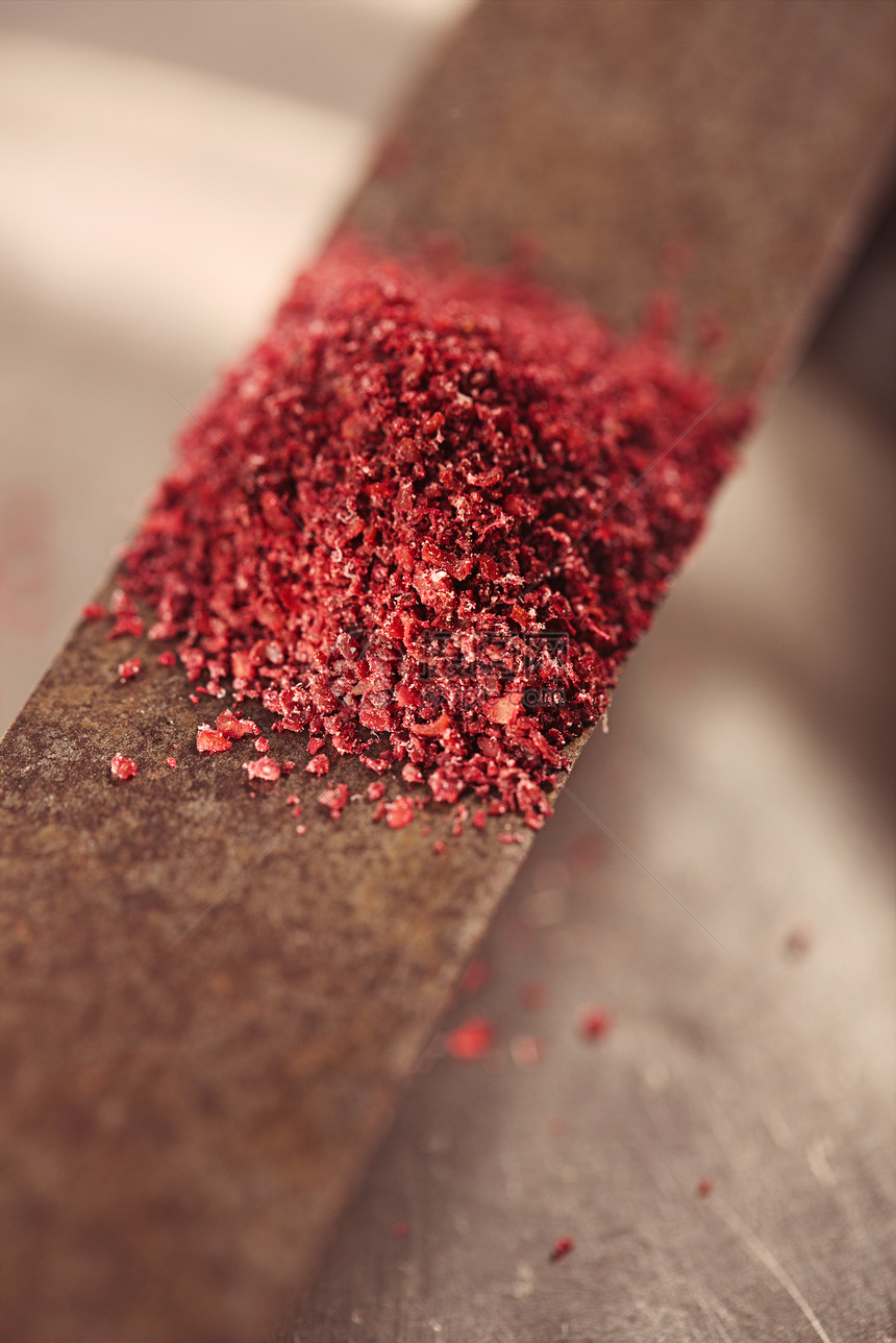 刀上磨碎的红漆树浆果香料图片
