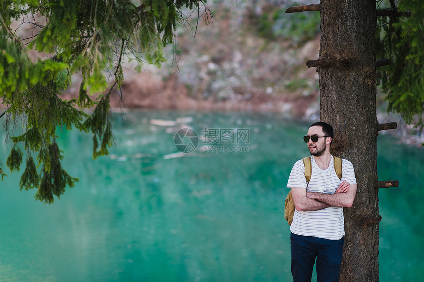 大胡子男模特在绿湖旁边摆姿势图片