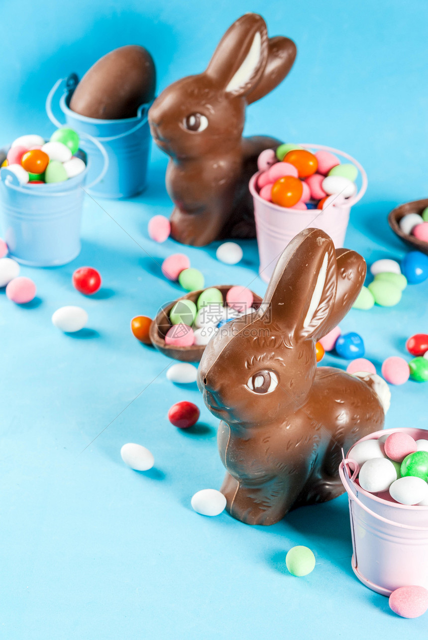 巧克力东面鸡蛋兔子和浅蓝色背景的糖果东方概图片