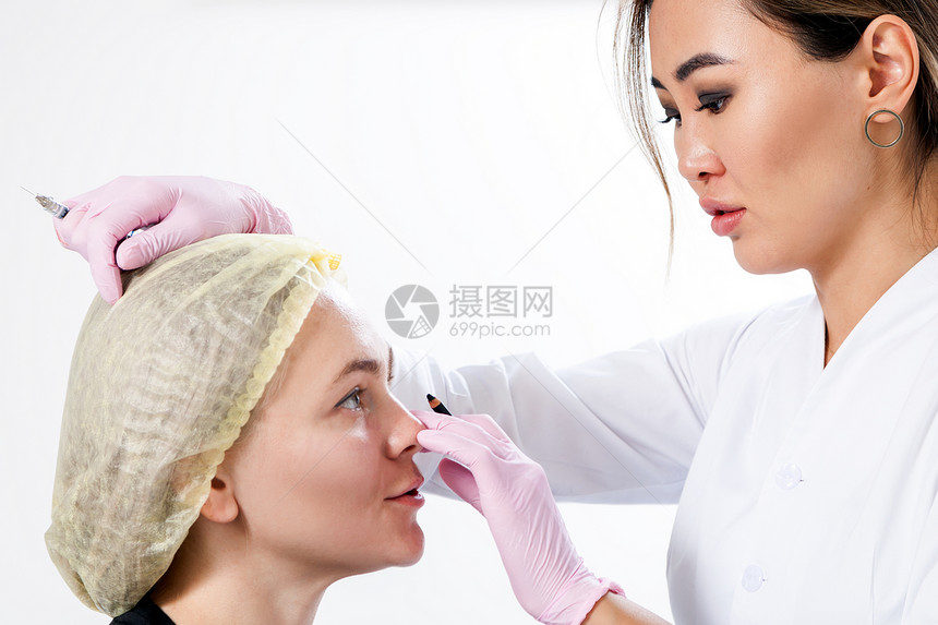 在肉毒注射帮助下对脸骨进行整顿的化妆程序女作为医生刺穿了一名年轻女子的脸盆图片