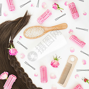 框架与梳子的头发造型卷发器卷发器和白色背景上的粉红玫瑰图片