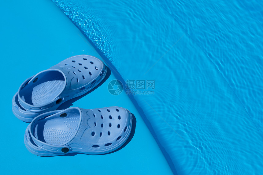 泳池附近的一双蓝色拖鞋图片
