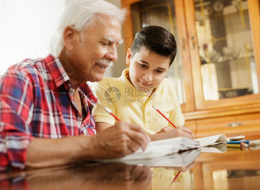 快乐的小男孩在家和老人一起做作业祖孙之间的家庭关系爷图片