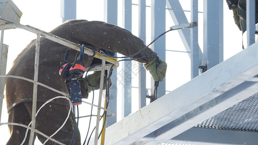 焊工在建筑工地冬季户外使用电弧焊时使用电极焊工防护面罩在冬季图片