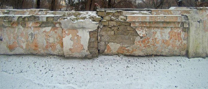 一块被雪覆盖的被破坏的砖墙老城的废墟后世界末日主题的废图片