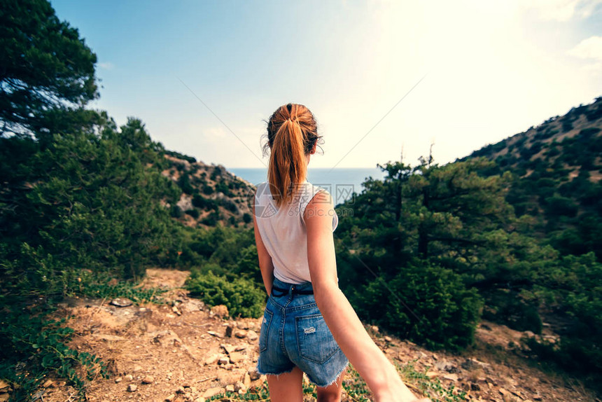 男人跟着他的女朋友牵着她的手在山上以大海为背景的户外行人旅行夏日里年图片