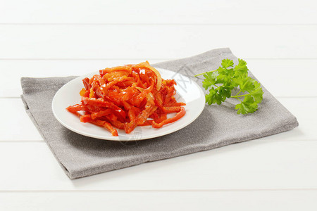 灰色餐垫上的一盘腌红辣椒图片