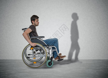 坐在轮椅上的年轻残疾男子有康复的希望图片