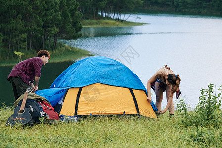 旅人在湖边搭帐篷过夜背景图片