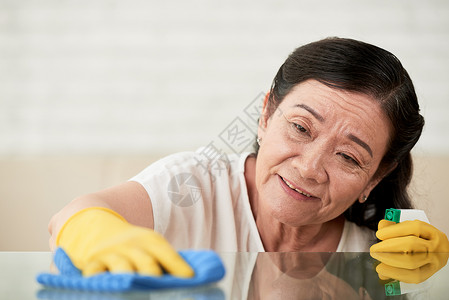 清洁女工从桌子的玻图片