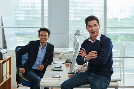 两位愉快的亚洲商人在办公室共图片