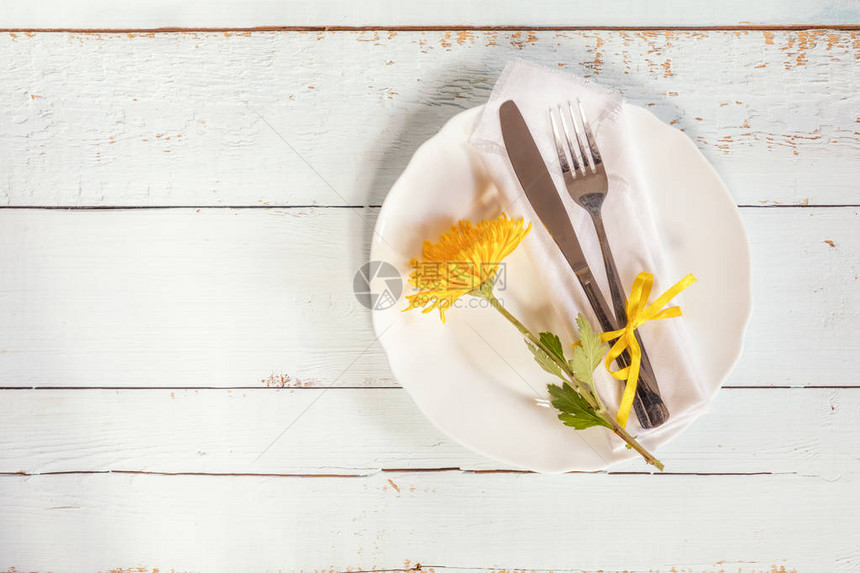 白色空板黄色的菊花餐巾叉子和刀图片