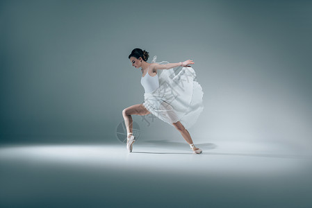 优雅的芭蕾舞女演员穿着白色连衣裙跳舞背景图片