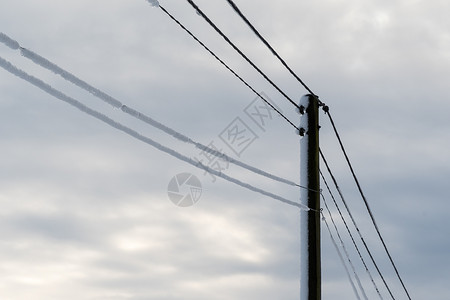 白雪皑的电线杆被雪覆盖的电力线图片