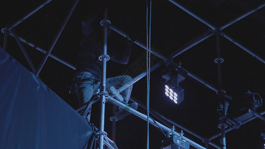 一个人爬上钢杆去修理和改变螺丝母图片