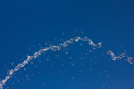 水滴在夏日的蓝天上飞溅水滴在背景中图片