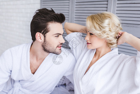 穿着浴袍的年轻美夫妇在卧室里图片