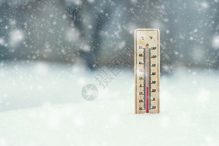 雪中的温度计显示暴风雪期间零的温度图片
